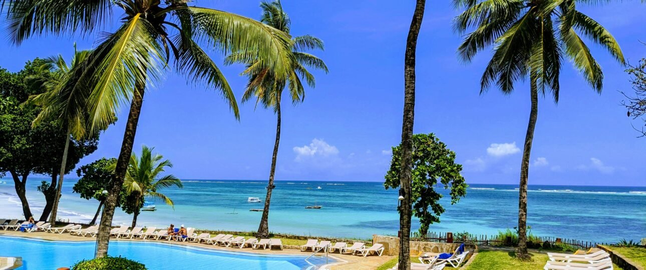 Mombasa Kenya beach resort with swimming pool, palm trees, sun loungers, and ocean view